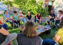eine Gruppe von Frauen sitzt im Pfarrgarten