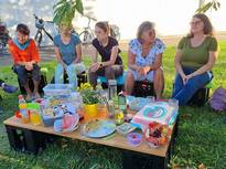 eine Gruppe von Frauen sitzt im Pfarrgarten